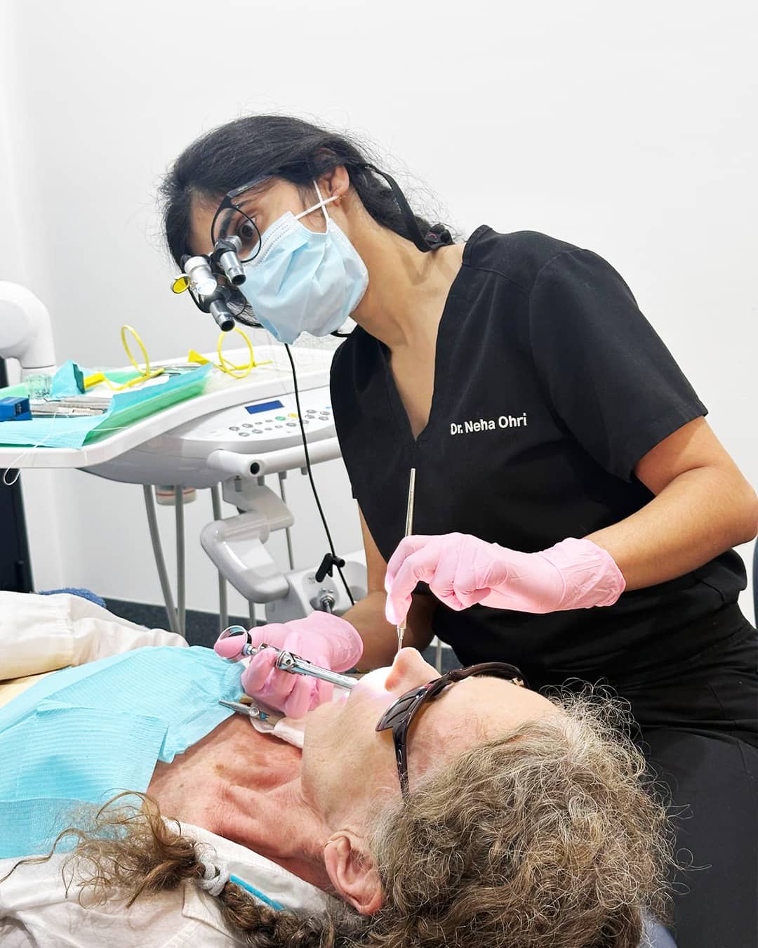 Dr. Neha Ohri performing treatment on a patient wearing protective glasses