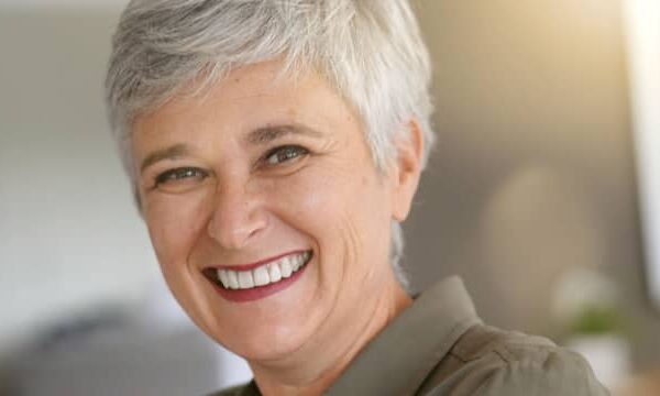 A happy senior woman showcasing the natural-looking results of dentures, demonstrating the comfort and confidence they provide.