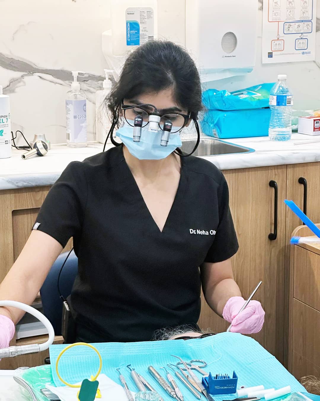 Dr. Neha Ohri preparing for a procedure with dental instruments arranged on a tray