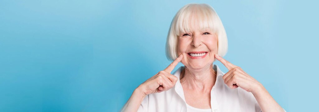 Happy senior patient pointing at teeth